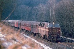 DSB MZ 1419 (type II) with passenger train heading for Fredericia. Photographed in Hannerup Skov, Fredericia.  The MZ class (type I and II) was purchased from 1967 to 1970 in a number of 26. Only a few of these engines remain in service by DSB - most are now sold to other companies. MZ 1419 was in 2002 sold to Banestyrelsen. Built by NOHAB and Frichs. Dieselelectric. Co'Co'. 2270 kW - 3300 hp. Max speed 143 km/h - 89 mph. Length 20 800 mm. Weight 116,5 metric tonnes.